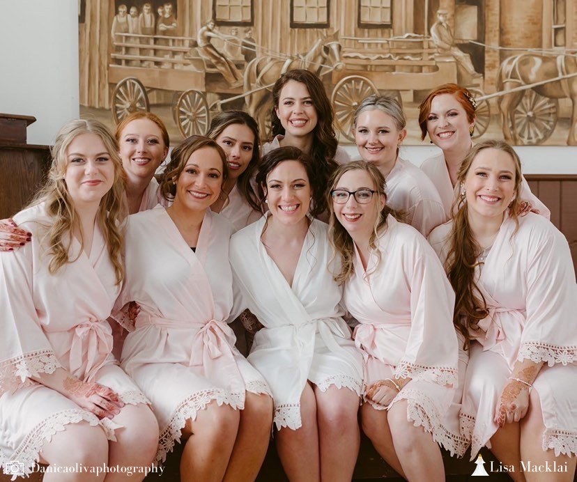 Bridal party wearing Aurora satin robes in white and blush. 431 the wedding company customer