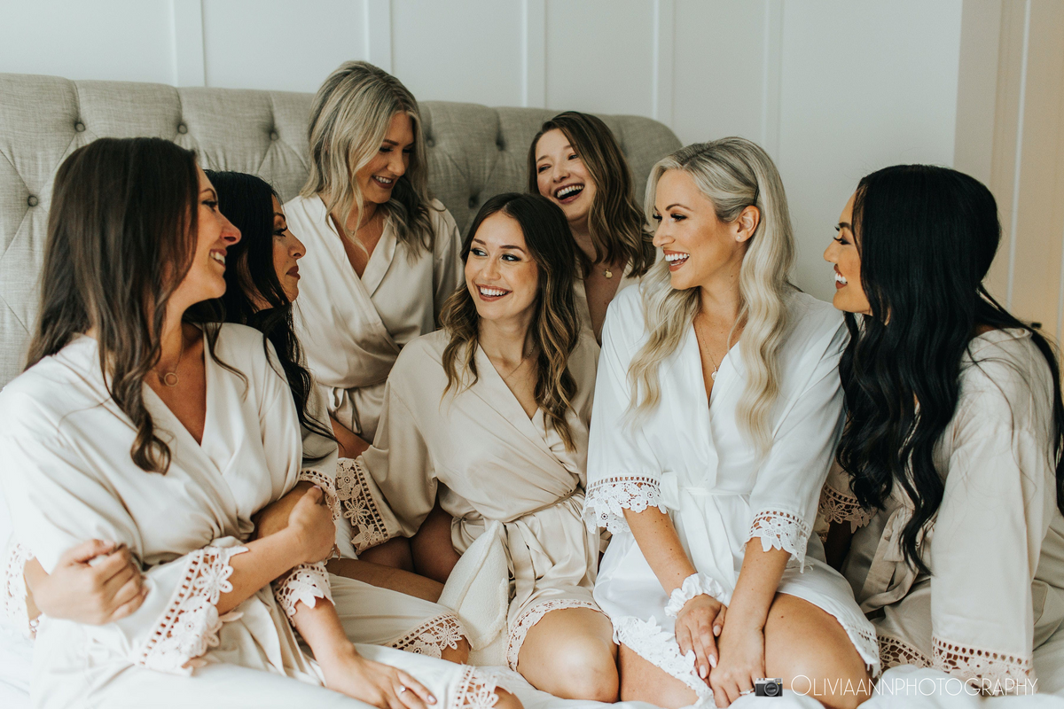 Bridal party group photo featuring the champagne satin and white robes