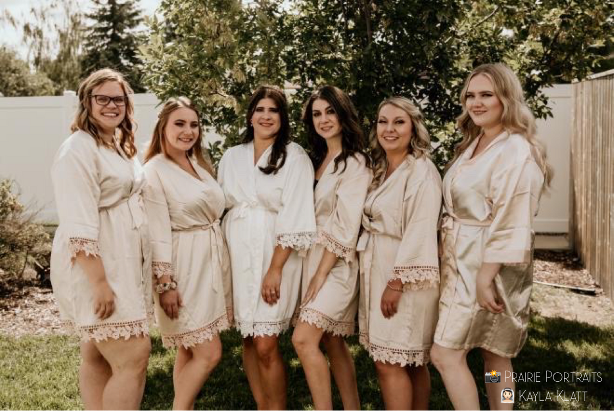 Bridal party group photo featuring the champagne and white satin robes