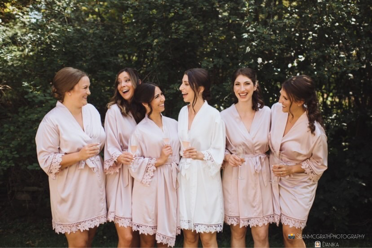 Bridal party wearing Aurora satin light mauve and white robes. 431 the wedding company customer