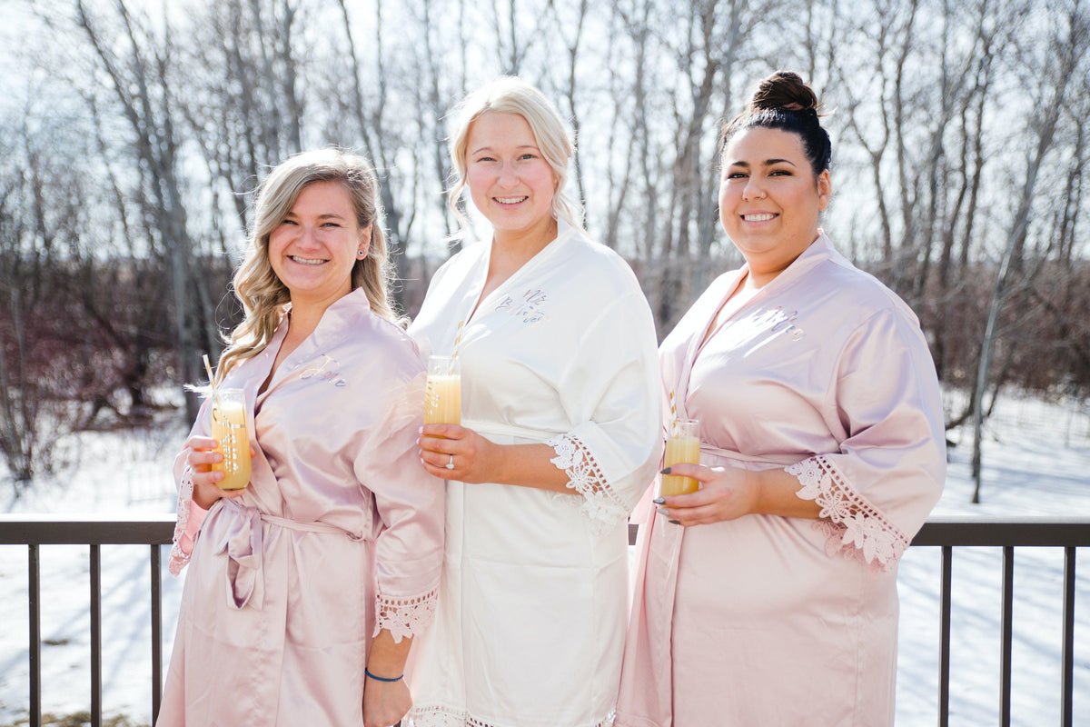 Bridal party wearing Aurora satin light mauve and white robes. 431 the wedding company customer
