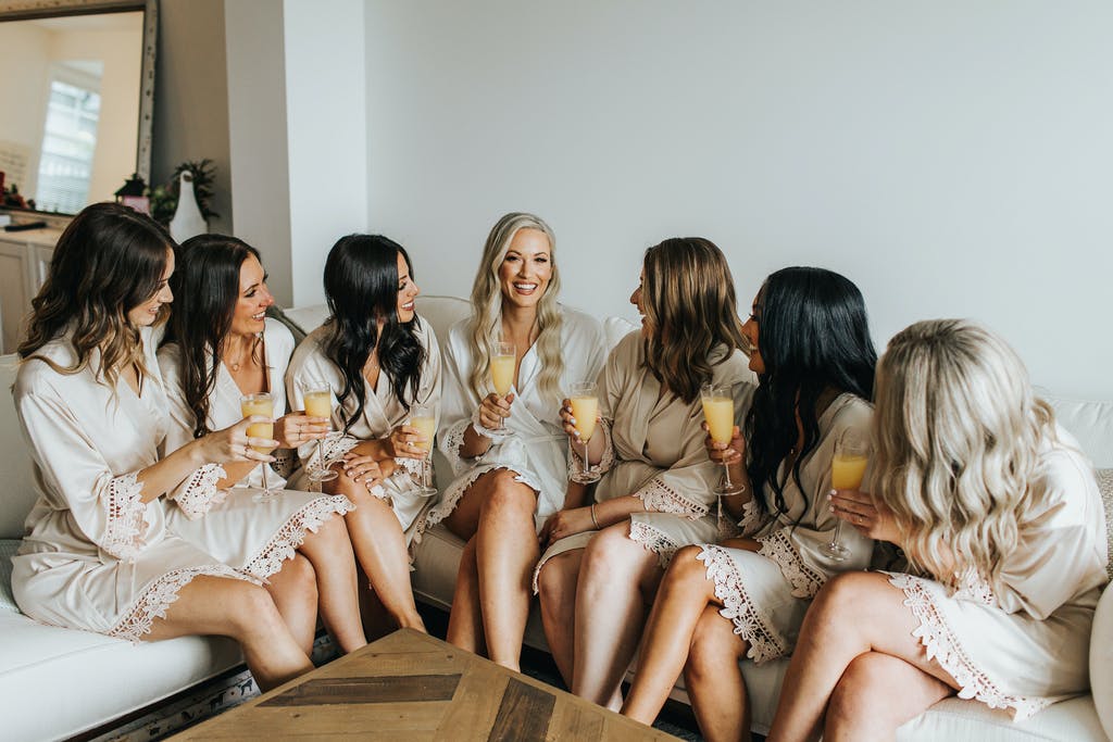 Bridal party group photo featuring the white and champagne satin robes