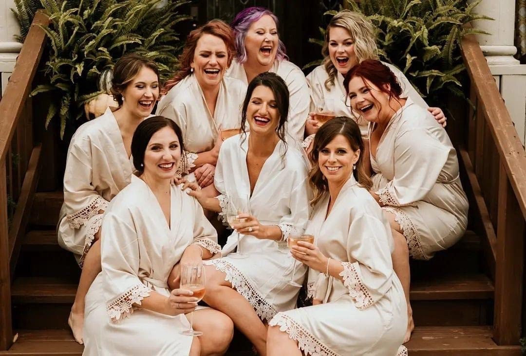 Bridal party group photo featuring the champagne and white satin aurora robes