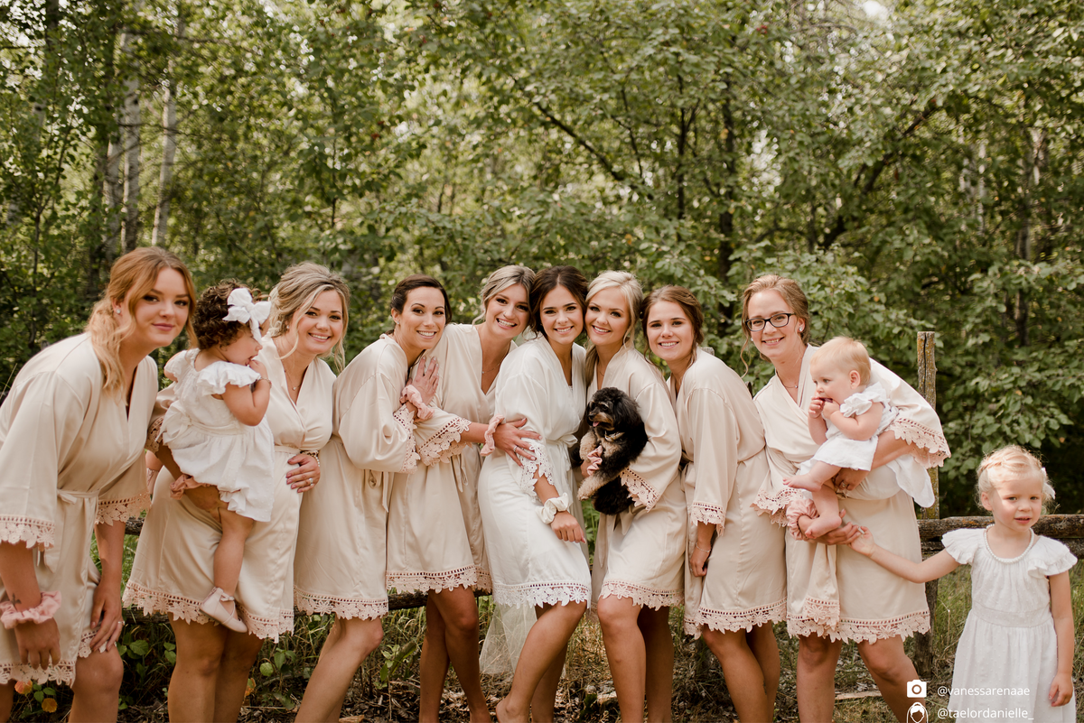 Bridal party group photo featuring the champagne and white satin robes